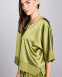 The Faberge Moss Silk Top from Christine Vancouver has a slightly cropped cut that hits at the upper hip on most, with a loose cut through the body and elbow length sleeves