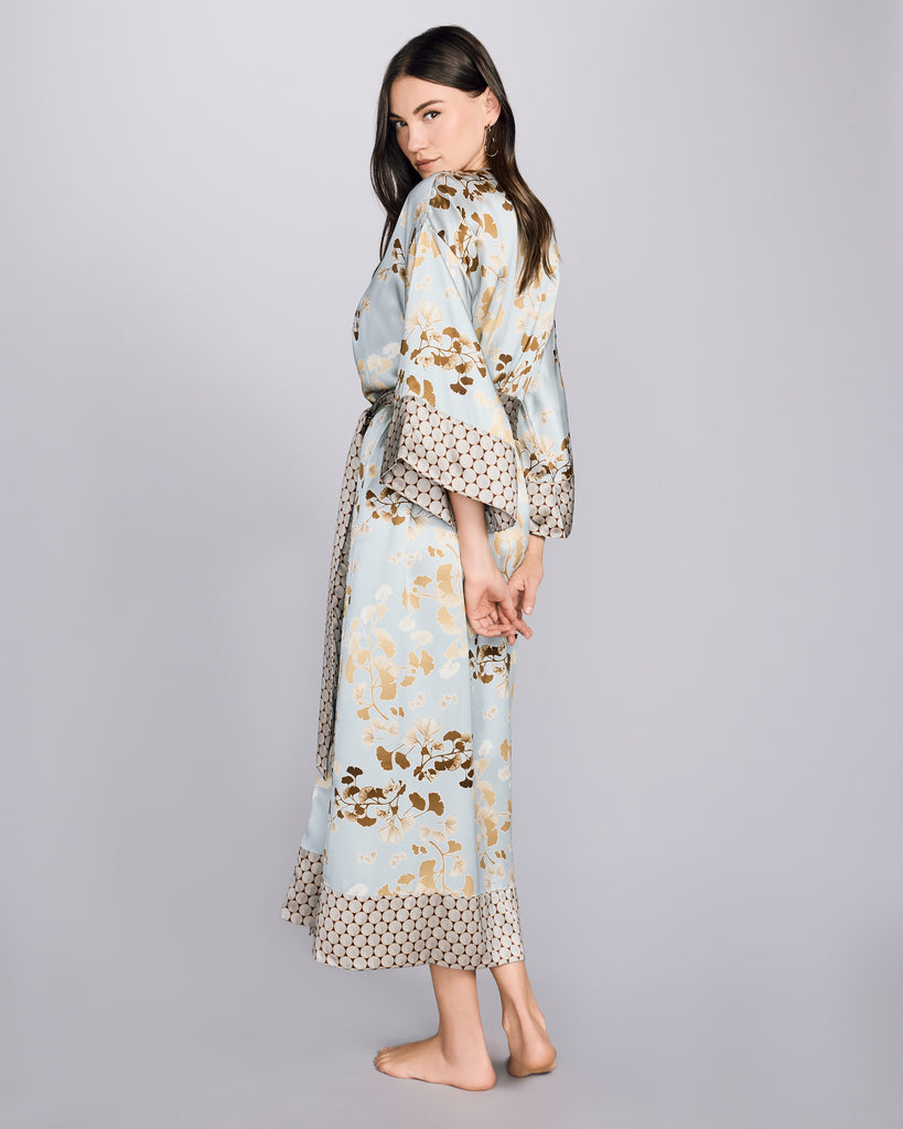 Full length Kazari Gold robe from Karma on the Rocks is crafted from a decadent silver grey silk charmeuse with a gingko print in shades of gold and khaki and a contrast print in shades of red and silver&nbsp;