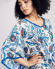 Emma Ducci's Santorini silk kaftan showcases a floral pattern in shades of blue, red, and black on a crisp white background
